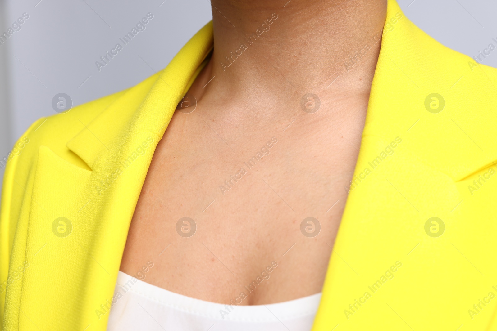 Young woman with healthy skin on light grey background, closeup Photo of Young woman with healthy skin on light grey background, closeup