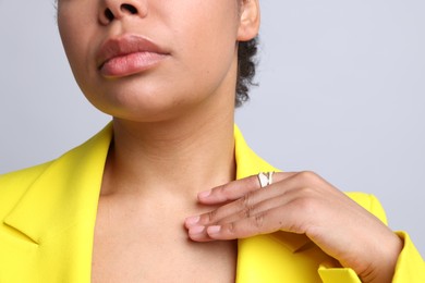 Photo of Young woman wearing elegant ring on light grey background, closeup