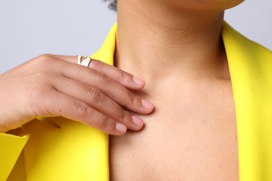 Photo of Young woman wearing elegant ring on light grey background, closeup
