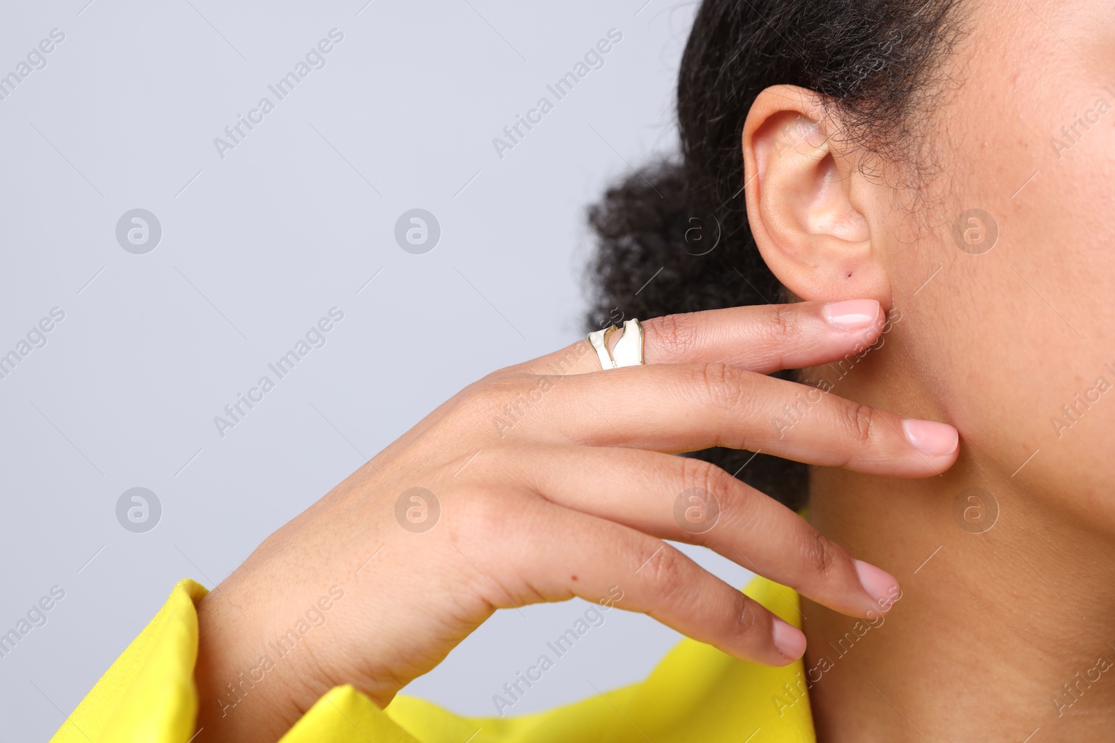 Young woman wearing elegant ring on light grey background, closeup. Space for text Photo of Young woman wearing elegant ring on light grey background, closeup. Space for text