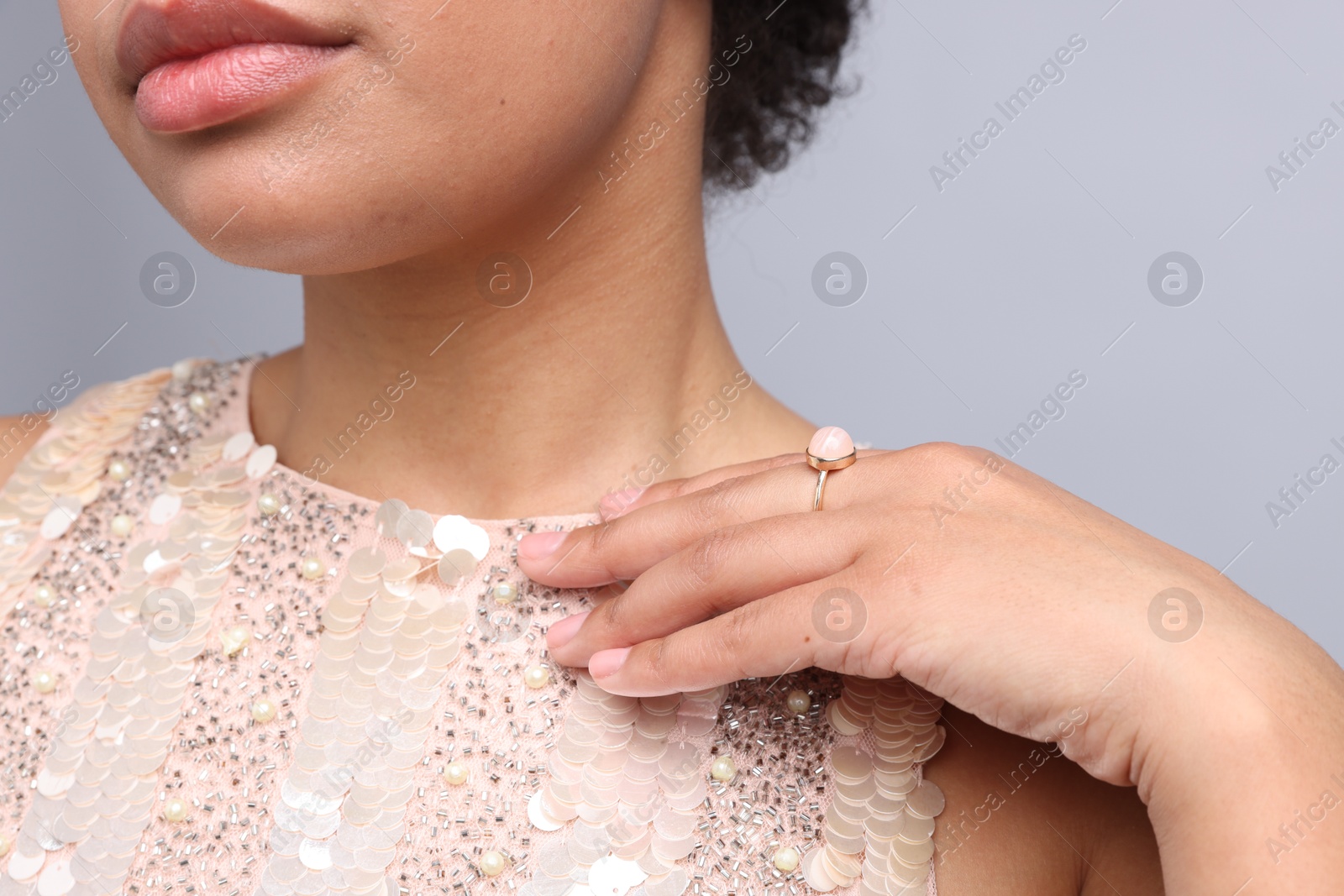 Photo of Young woman wearing elegant ring on light grey background, closeup