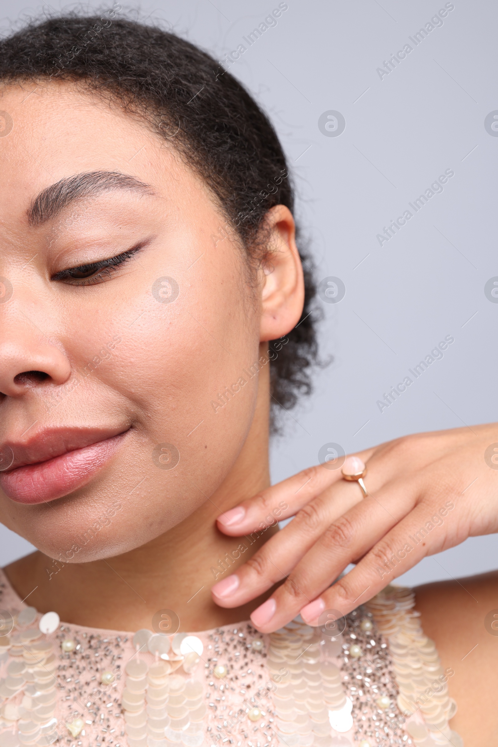 Photo of Young woman wearing elegant ring on light grey background, closeup
