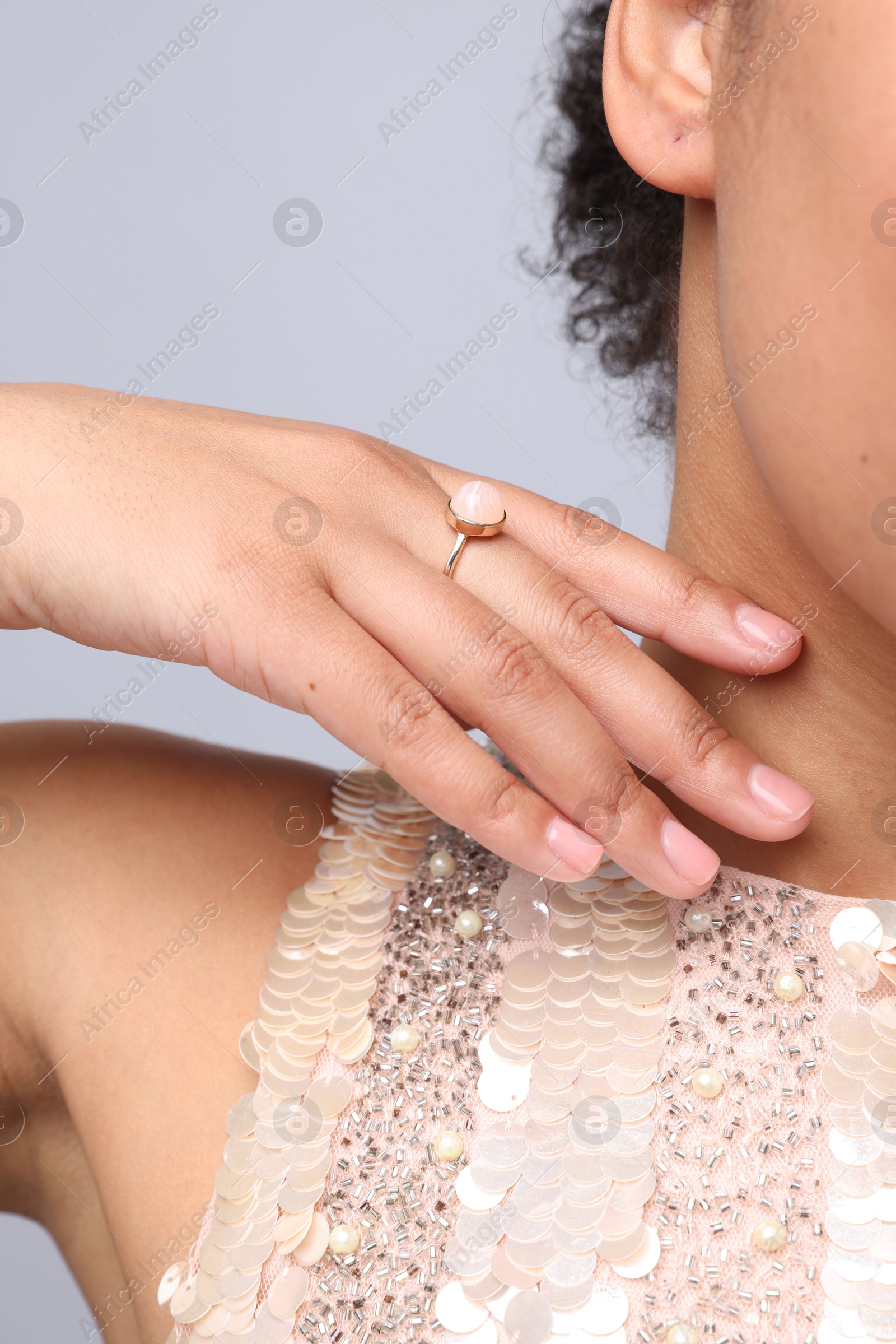 Young woman wearing elegant ring on light grey background, closeup Photo of Young woman wearing elegant ring on light grey background, closeup
