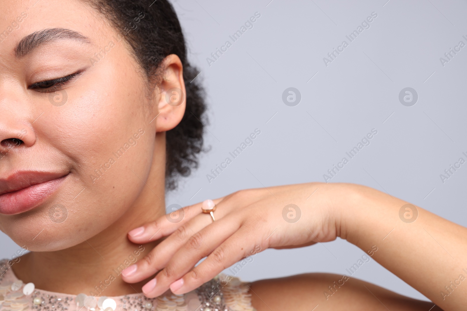 Young woman wearing elegant ring on light grey background, closeup. Space for text Photo of Young woman wearing elegant ring on light grey background, closeup. Space for text