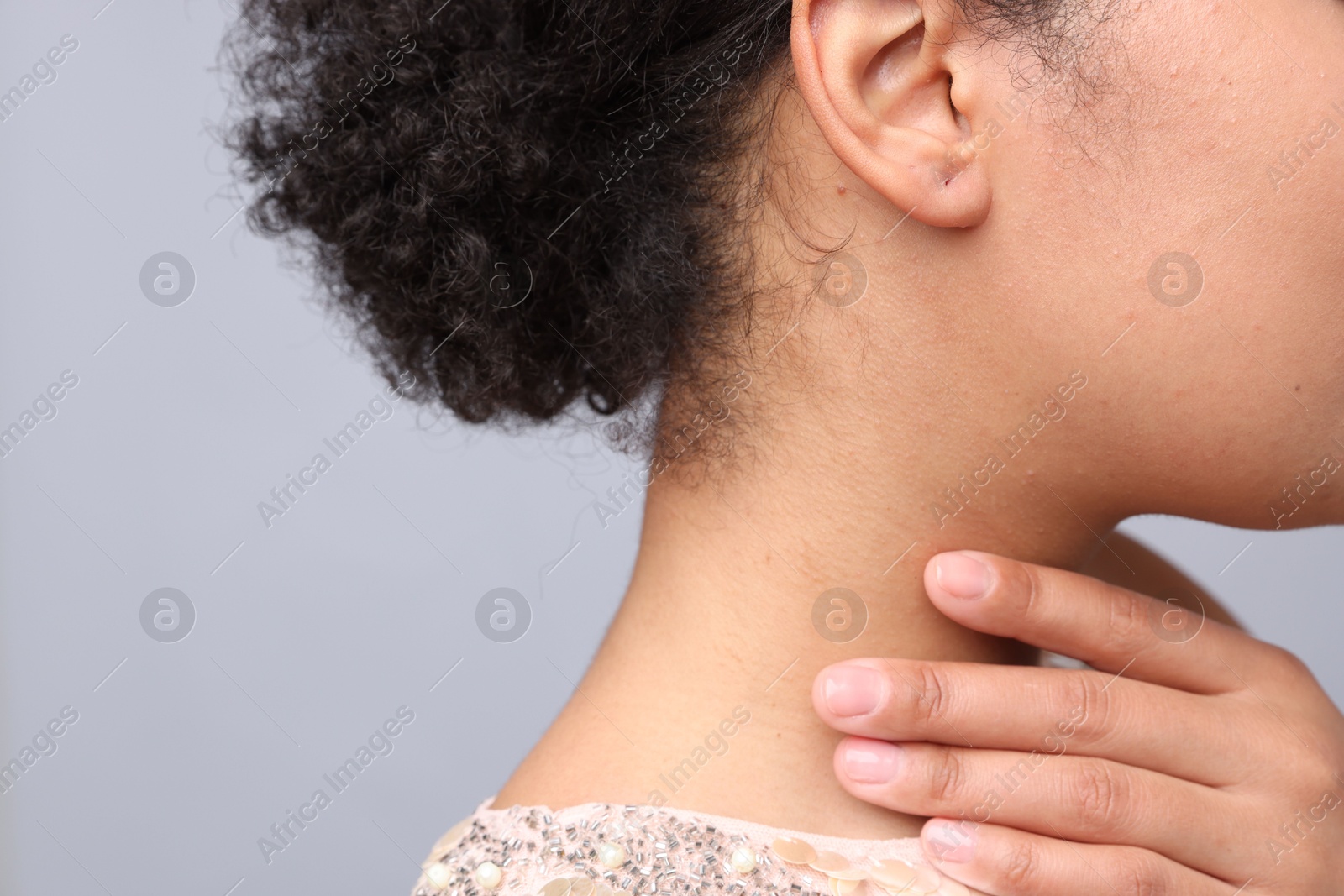 Young woman with pierced ear on light grey background, closeup Photo of Young woman with pierced ear on light grey background, closeup