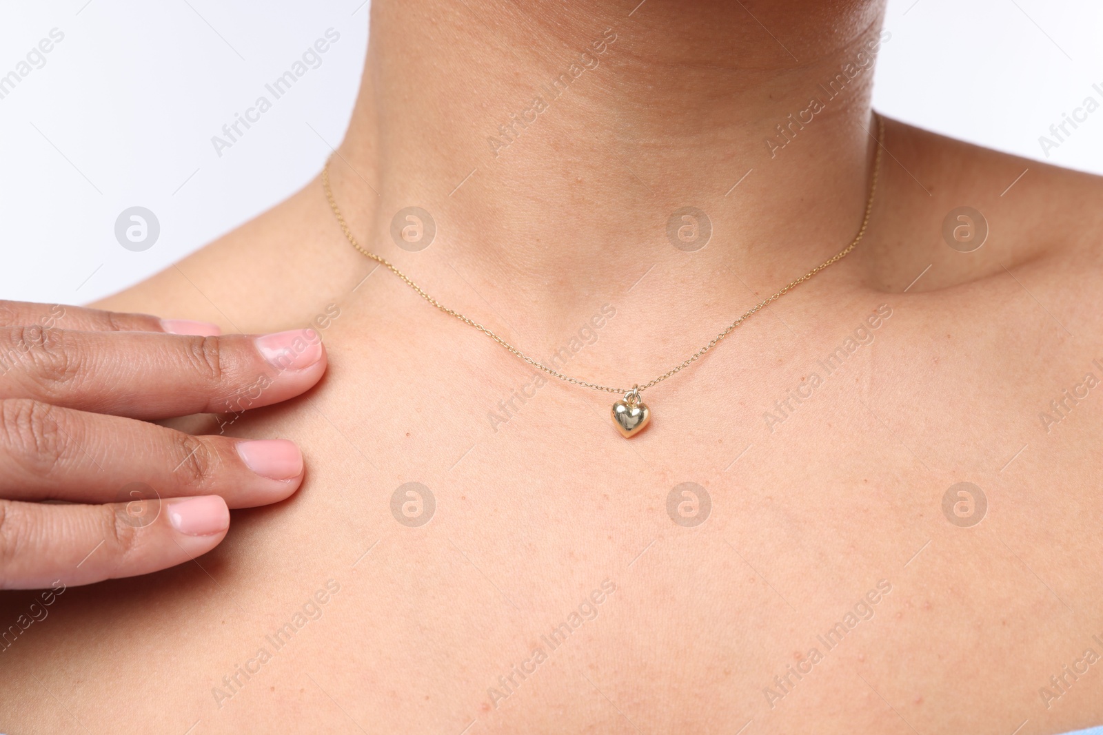 Photo of Young woman wearing elegant gold necklace on white background, closeup