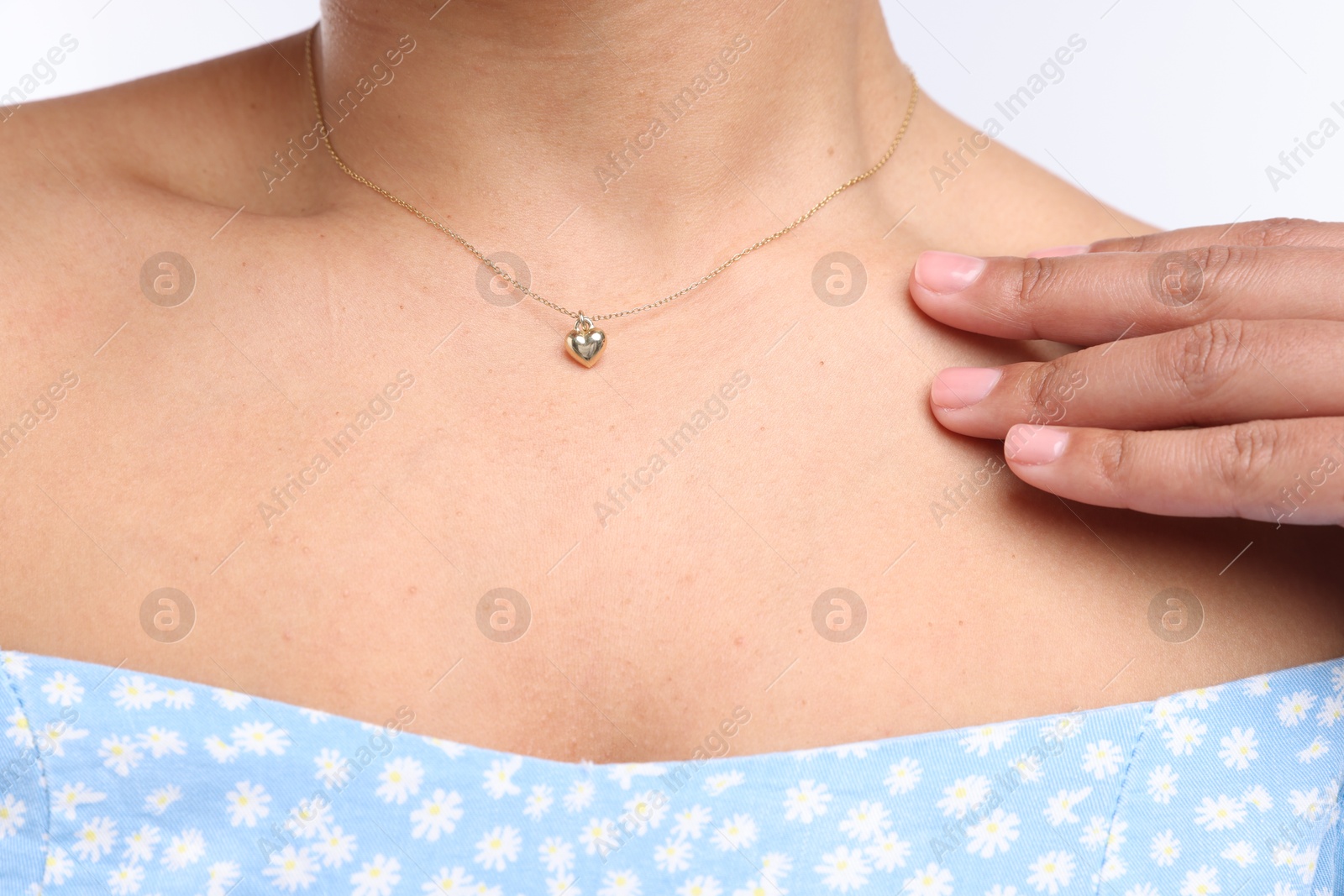 Photo of Young woman wearing elegant gold necklace on white background, closeup