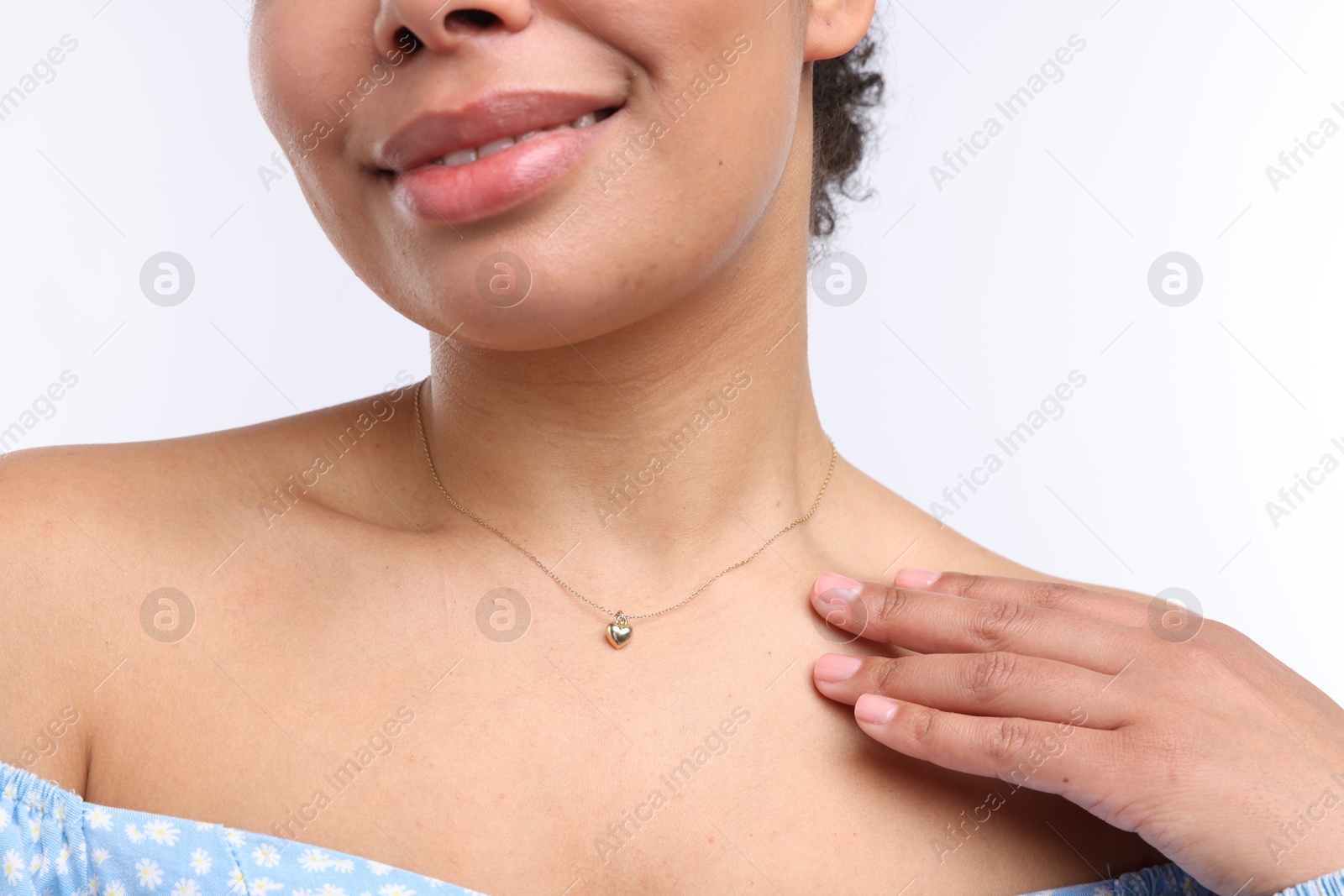 Photo of Young woman wearing elegant gold necklace on white background, closeup