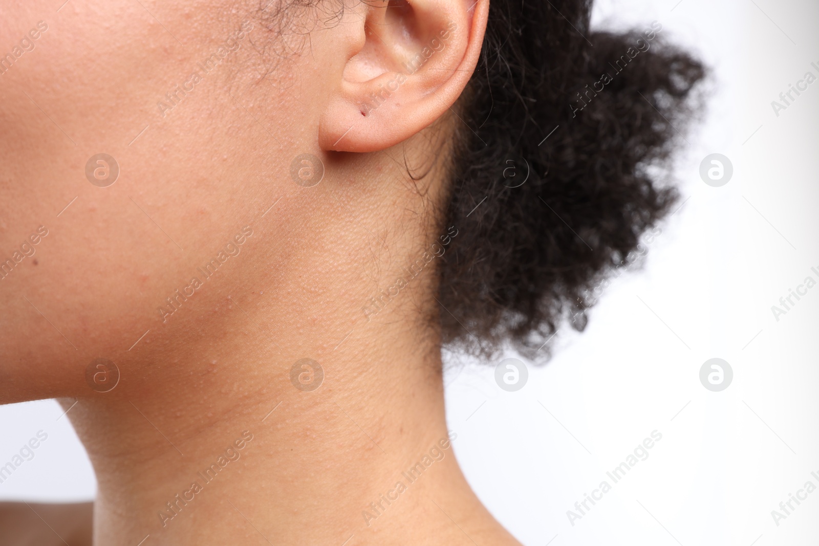Young woman with pierced ear on white background, closeup Photo of Young woman with pierced ear on white background, closeup
