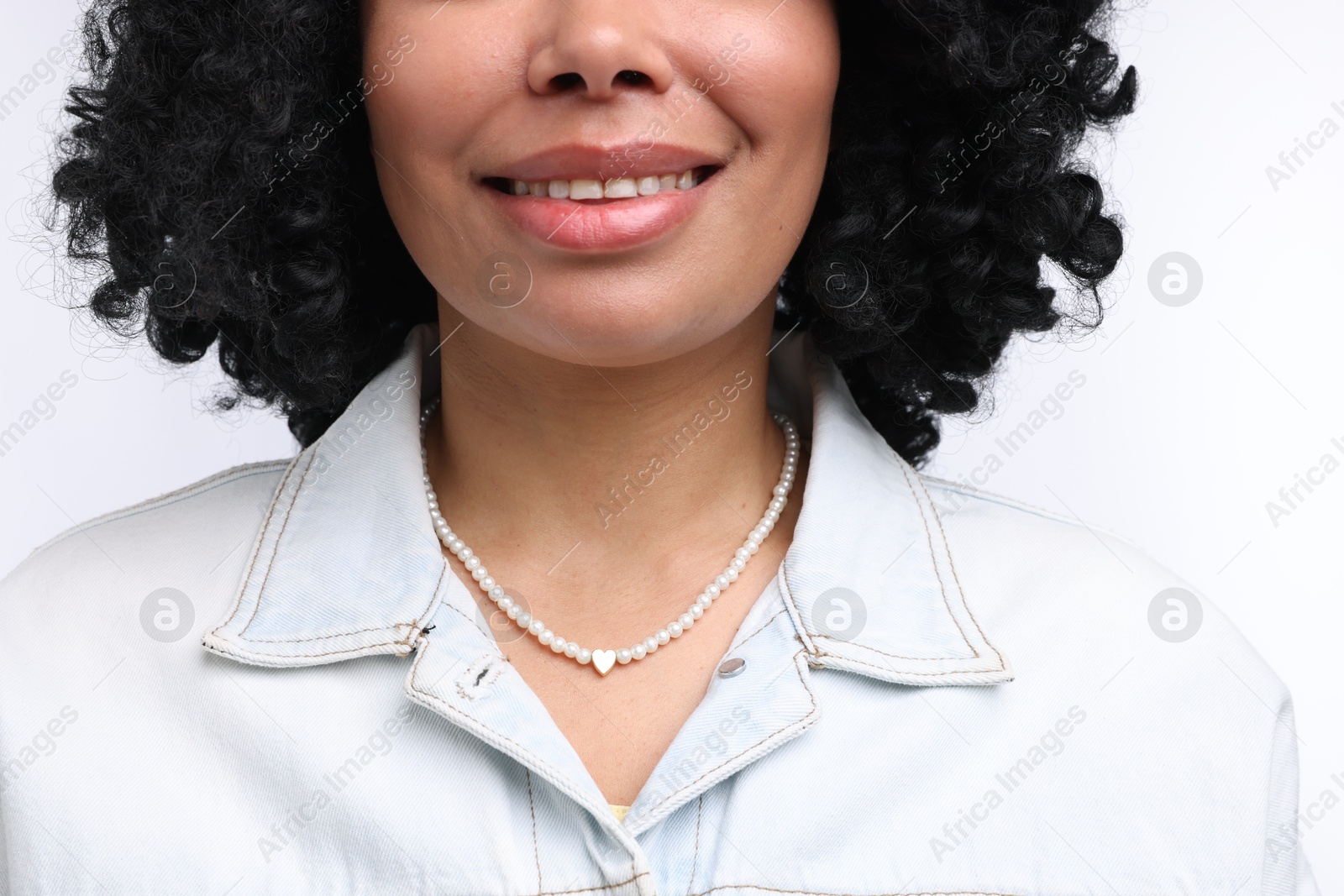 Young woman wearing elegant pearl necklace on white background, closeup Photo of Young woman wearing elegant pearl necklace on white background, closeup