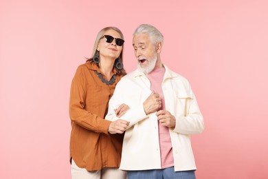 Photo of Senior couple in stylish outfits on pink background