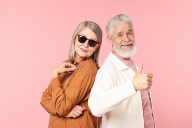 Photo of Senior couple in stylish outfits on pink background