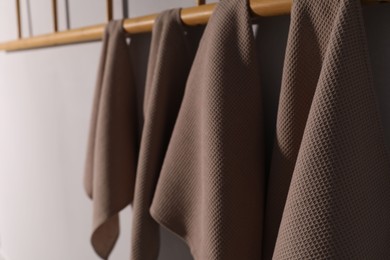 Photo of Clean waffle towels hanging on light wall, closeup