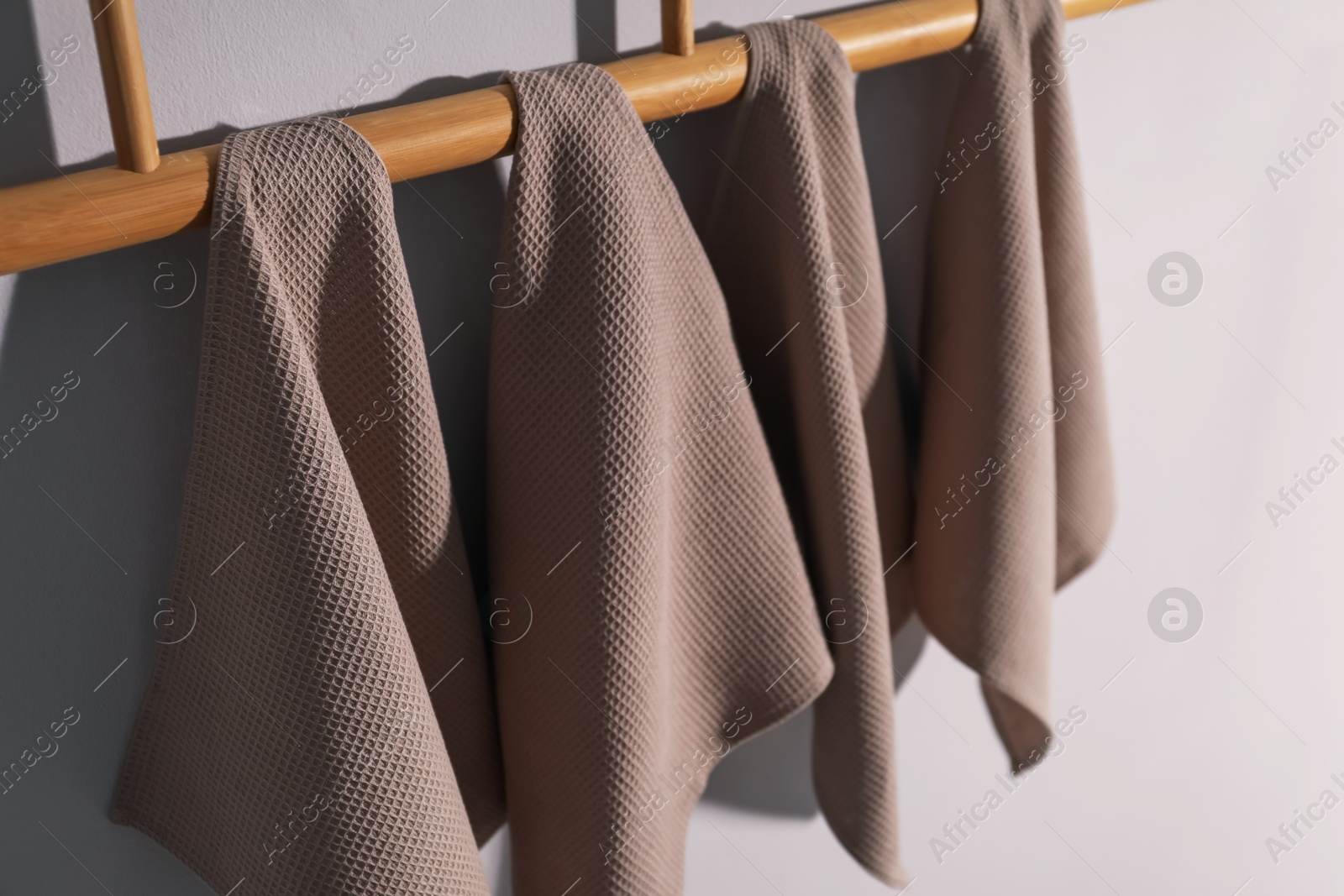 Clean waffle towels hanging on light wall, closeup Photo of Clean waffle towels hanging on light wall, closeup