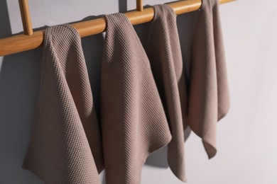 Photo of Clean waffle towels hanging on light wall, closeup