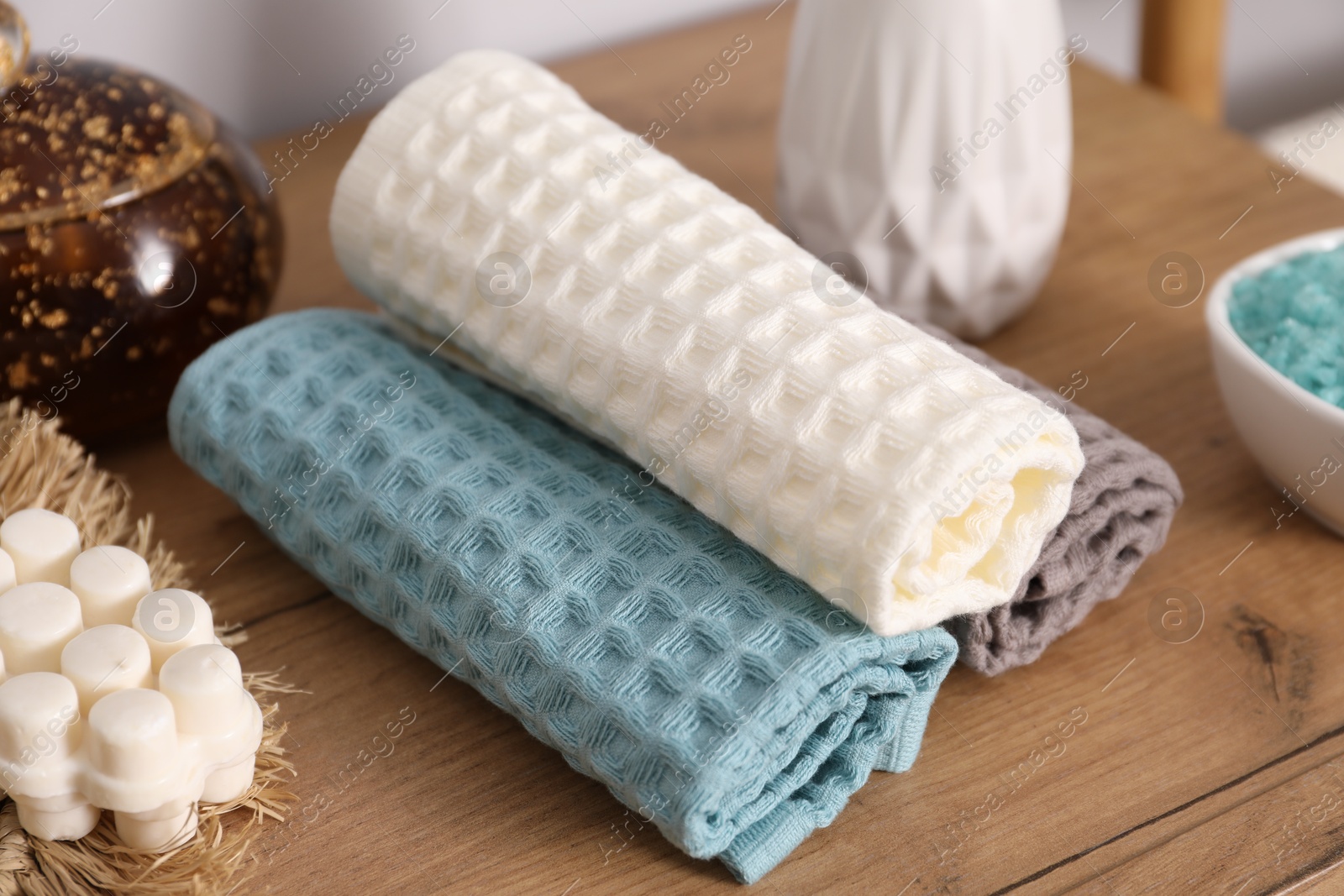 Clean waffle towels and other bath products on wooden dresser, closeup Photo of Clean waffle towels and other bath products on wooden dresser, closeup
