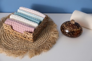 Photo of Clean waffle towels in wicker basket on white dresser in bathroom, closeup