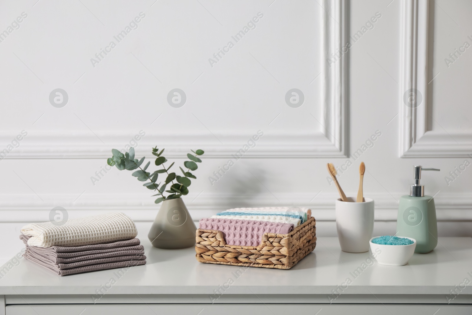 Clean waffle towels and other bath products on white dresser in bathroom Photo of Clean waffle towels and other bath products on white dresser in bathroom