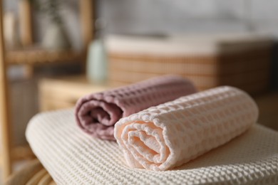 Photo of Clean waffle towels on chair in bathroom, closeup