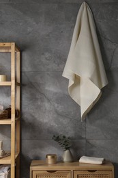 Photo of Clean waffle towels and other bath products near grey wall in bathroom