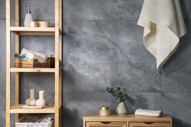 Photo of Clean waffle towels and other bath products near grey wall in bathroom
