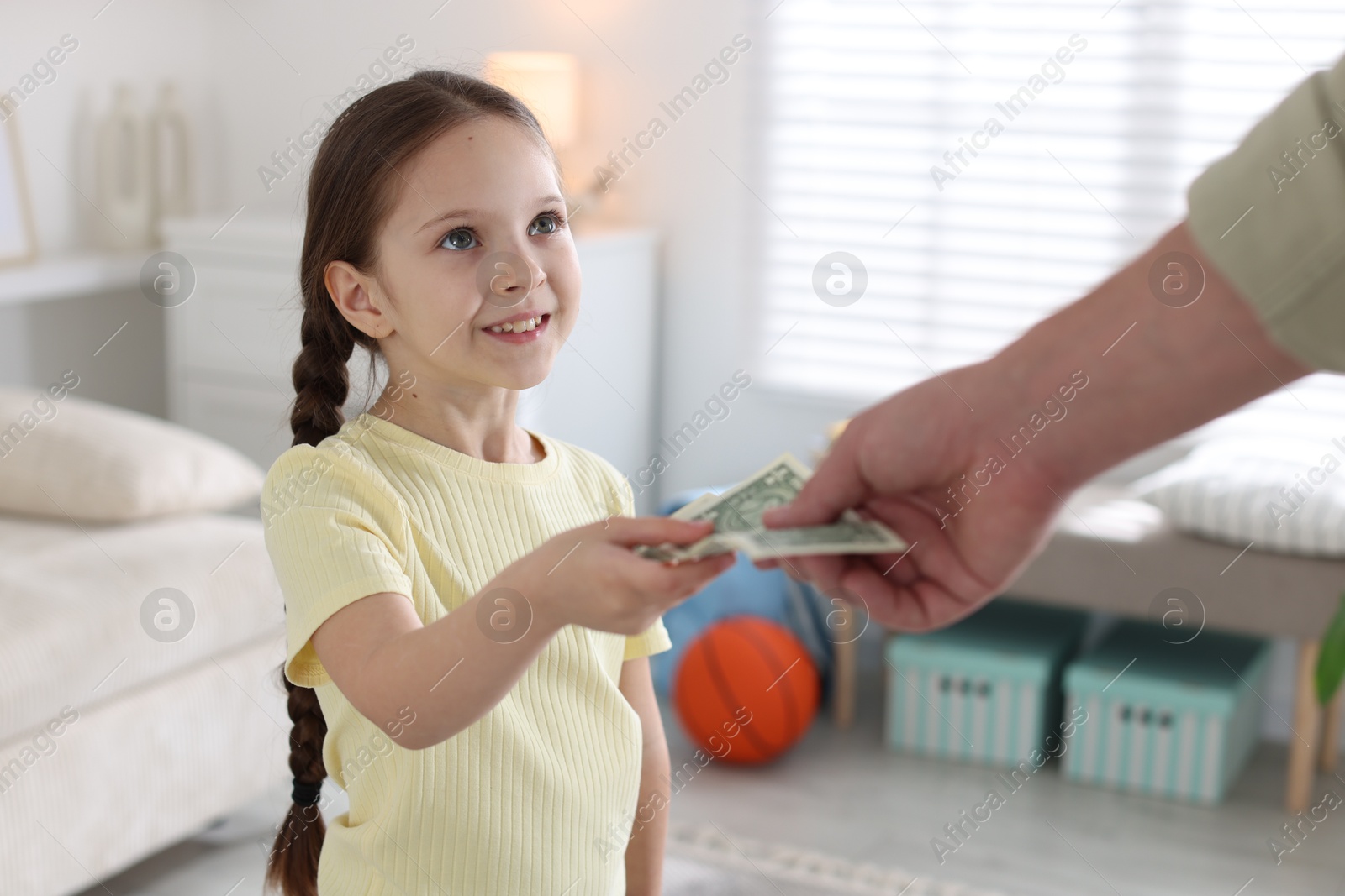 Father giving his daughter pocket money at home, closeup Photo of Father giving his daughter pocket money at home, closeup