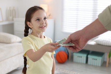 Photo of Father giving his daughter pocket money at home, closeup