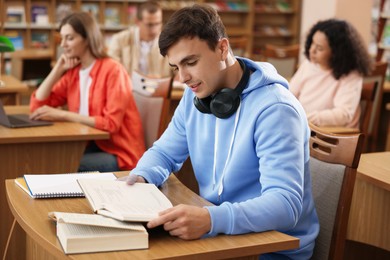 Photo of People studying at desks in public library, selective focus