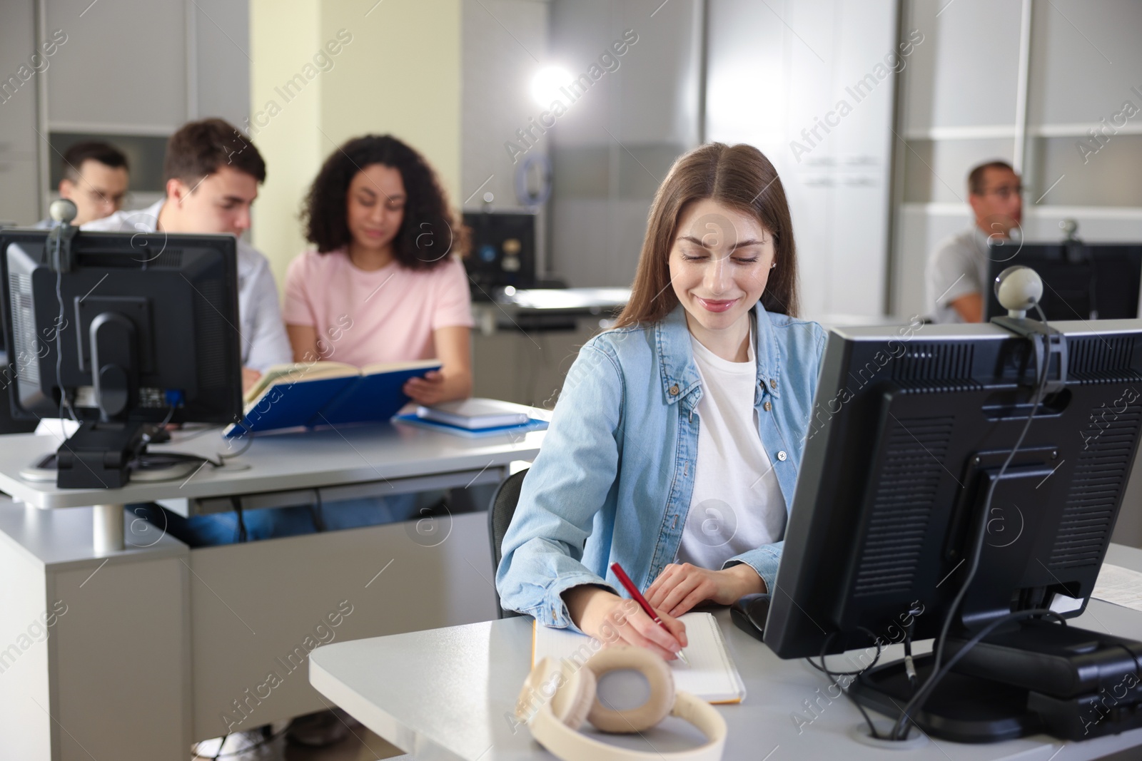 People working at desks in library, selective focus Photo of People working at desks in library, selective focus