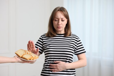 Photo of Gluten free diet. Woman refusing from bread indoors