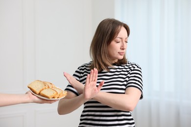 Photo of Gluten free diet. Woman refusing from bread indoors