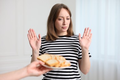 Photo of Gluten free diet. Woman refusing from bread indoors