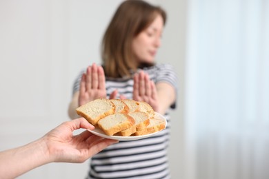 Photo of Gluten free diet. Woman refusing from bread indoors, selective focus