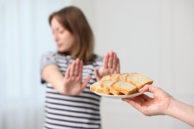 Photo of Gluten free diet. Woman refusing from bread indoors, selective focus