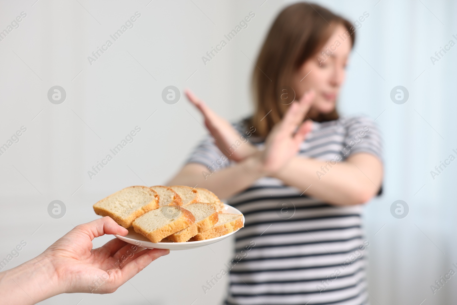 Photo of Gluten free diet. Woman refusing from bread indoors, selective focus