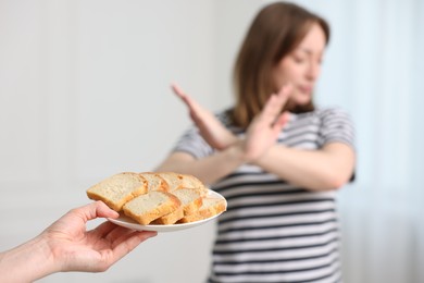 Photo of Gluten free diet. Woman refusing from bread indoors, selective focus