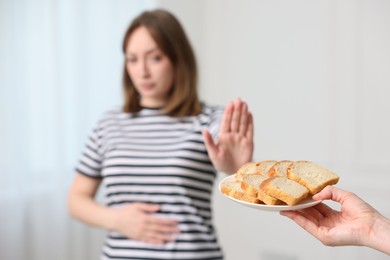 Photo of Gluten free diet. Woman refusing from bread indoors, selective focus