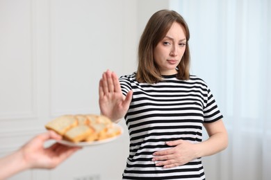 Photo of Gluten free diet. Woman refusing from bread indoors