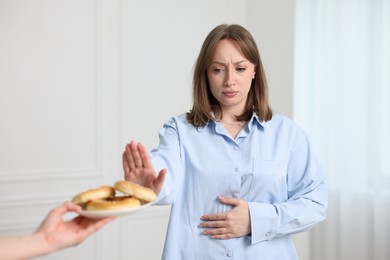 Photo of Gluten free diet. Woman refusing from pretzels indoors