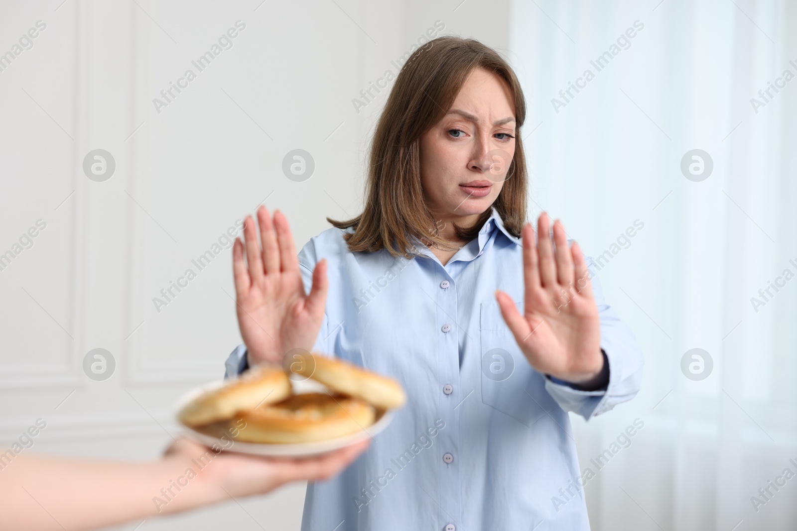 Photo of Gluten free diet. Woman refusing from pretzels indoors
