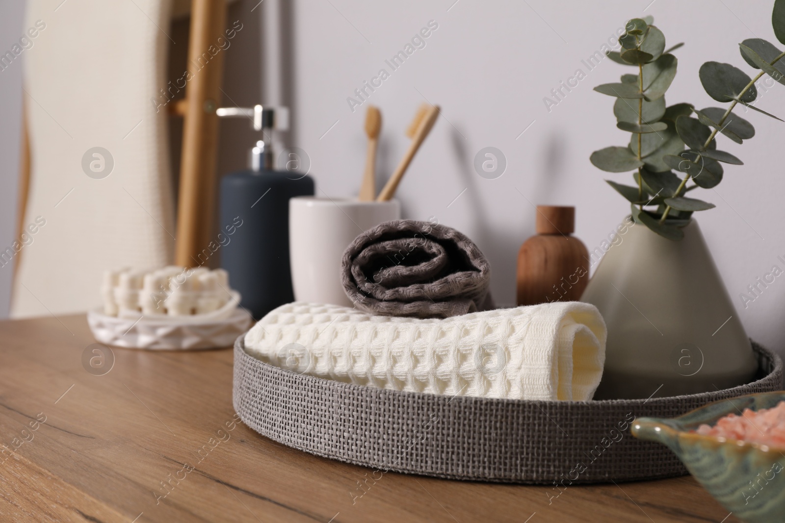 Clean waffle towels and other bath products on wooden dresser, closeup Photo of Clean waffle towels and other bath products on wooden dresser, closeup
