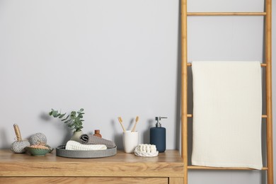 Photo of Clean waffle towels and other bath products on wooden dresser
