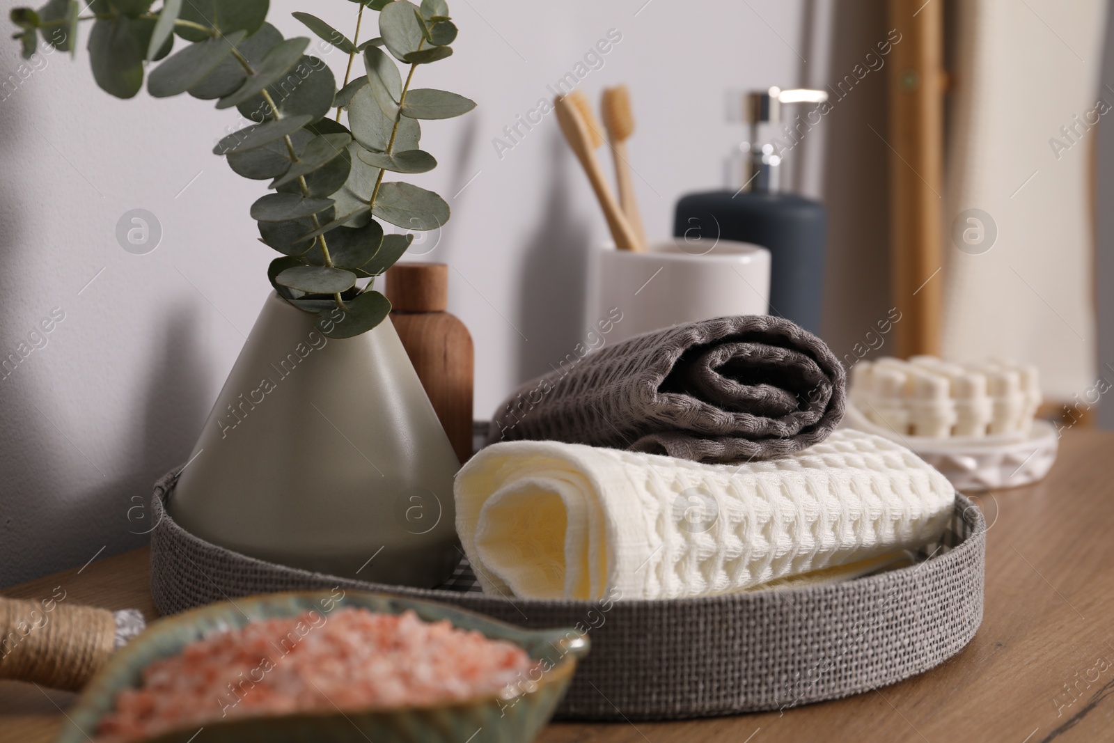 Clean waffle towels and other bath products on wooden dresser, closeup Photo of Clean waffle towels and other bath products on wooden dresser, closeup