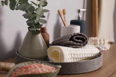 Photo of Clean waffle towels and other bath products on wooden dresser, closeup