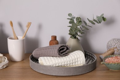 Photo of Clean waffle towels and other bath products on wooden dresser