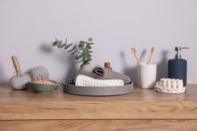 Photo of Clean waffle towels and other bath products on wooden dresser