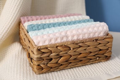 Photo of Clean waffle towels in wicker basket, closeup
