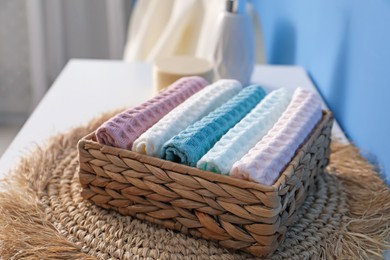 Photo of Clean waffle towels in wicker basket on dresser in bathroom, closeup
