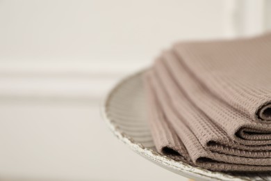 Photo of Clean waffle towels on side table against blurred background, closeup. Space for text