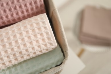 Photo of Clean waffle towels in basket on blurred background, above view. Space for text